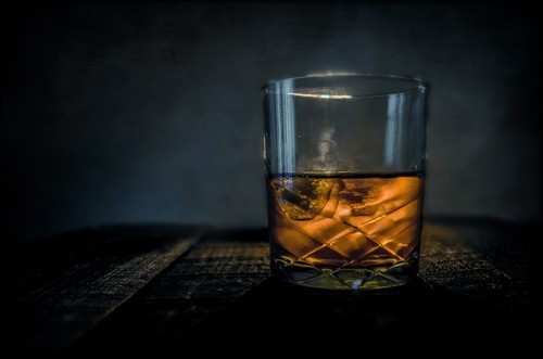 Glass of whiskey on a wooden table