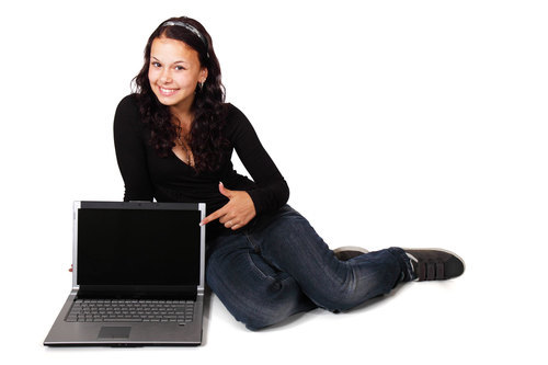 Flickan sitter bredvid datorn