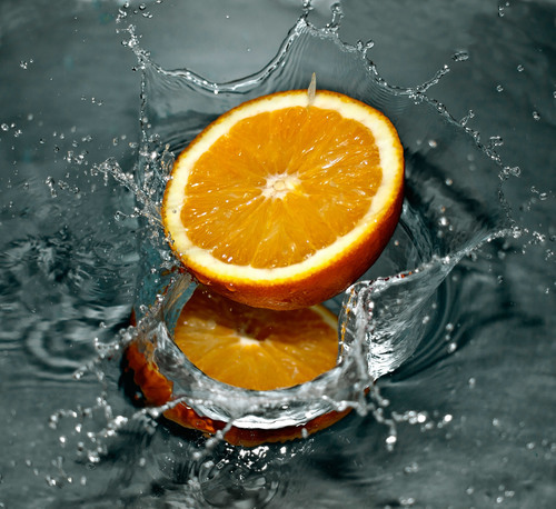 A half of orange splashes in the water
