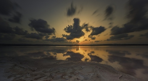 Dramatiska solnedgången på sandstranden