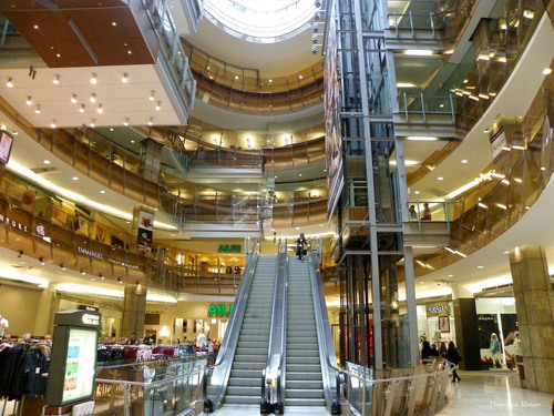 Interior de centro comercial con escaleras mecánicas