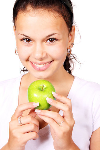 Ung kvinna med grönt äpple