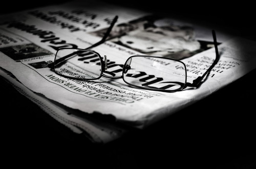 Newspaper with reading glasses