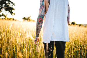 Homem tatuado em gramado