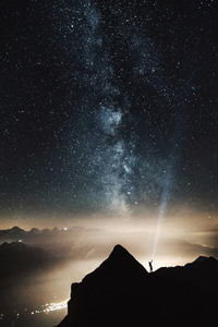 Céu estrelado com homem na montanha