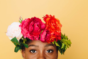Menina africana com as rosas em seu cabelo
