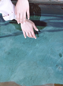 Mani delle ragazze sopra l'acqua
