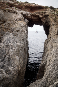 Boat under a rocky arch