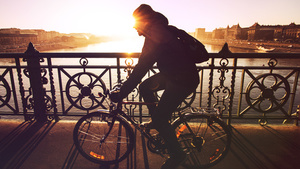 Mannen på cykel över bron