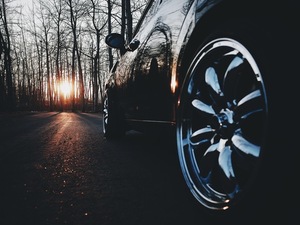 Cerchio cromato su una macchina nera sul tramonto