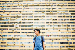 Menino japonês em frente ao prédio amarelo