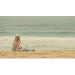 Jeune fille assise sur la plage