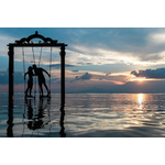 Man and woman swinging in the ocean